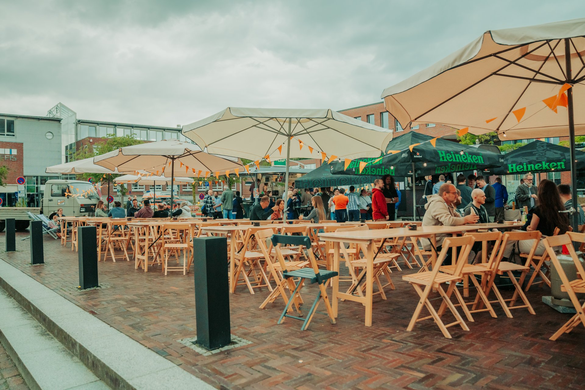 Zahlreiche Menschen sitzen an Tischen auf einem Straßenfest