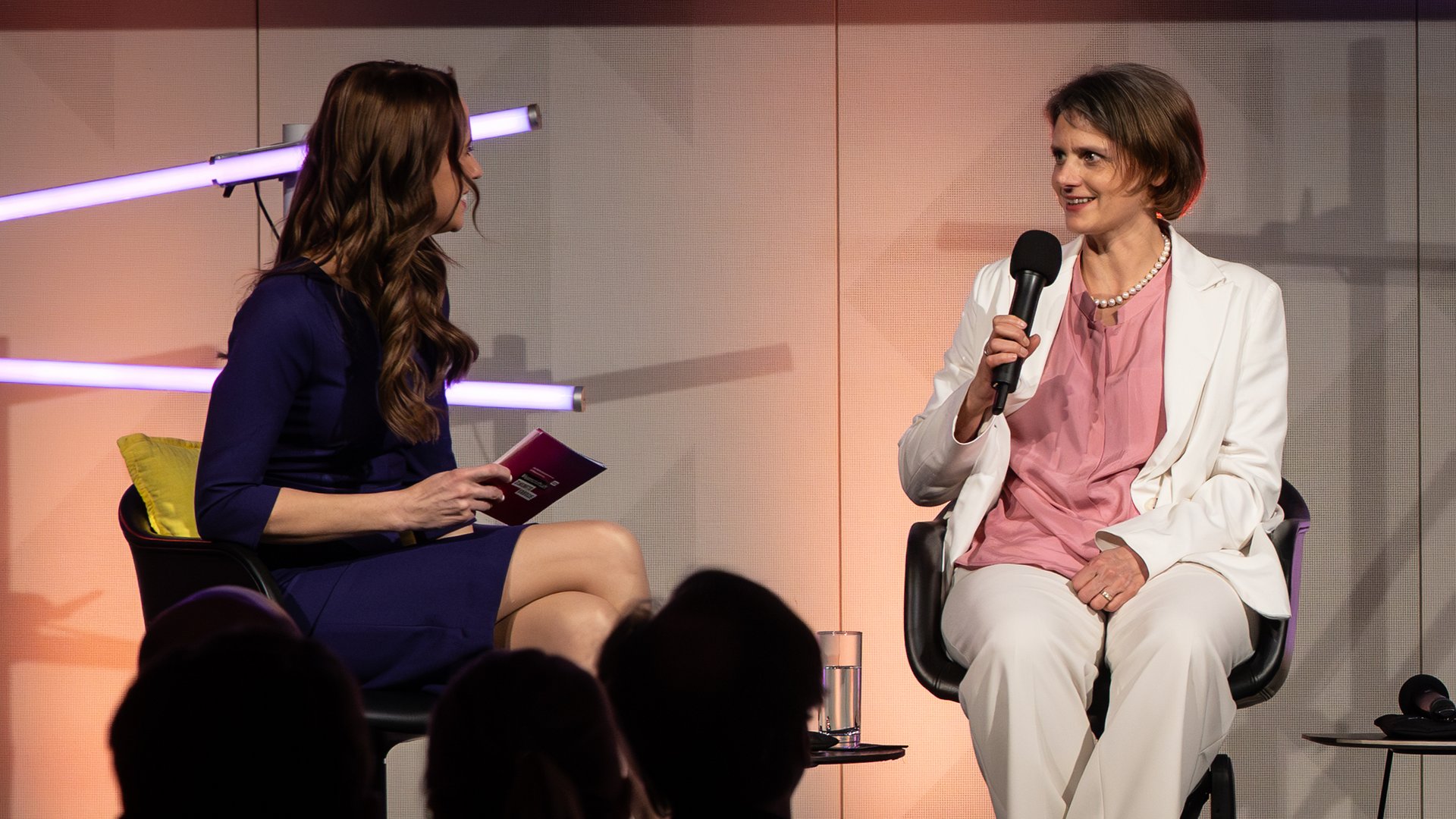 Dr. Anna Heimsath, Leiterin des Geschäftsfeldes Solarkraftwerke und Integrierte PV am Fraunhofer ISE, sitzt neben der Moderatorin Susanne Schöne und spricht in ein Mikrofon.