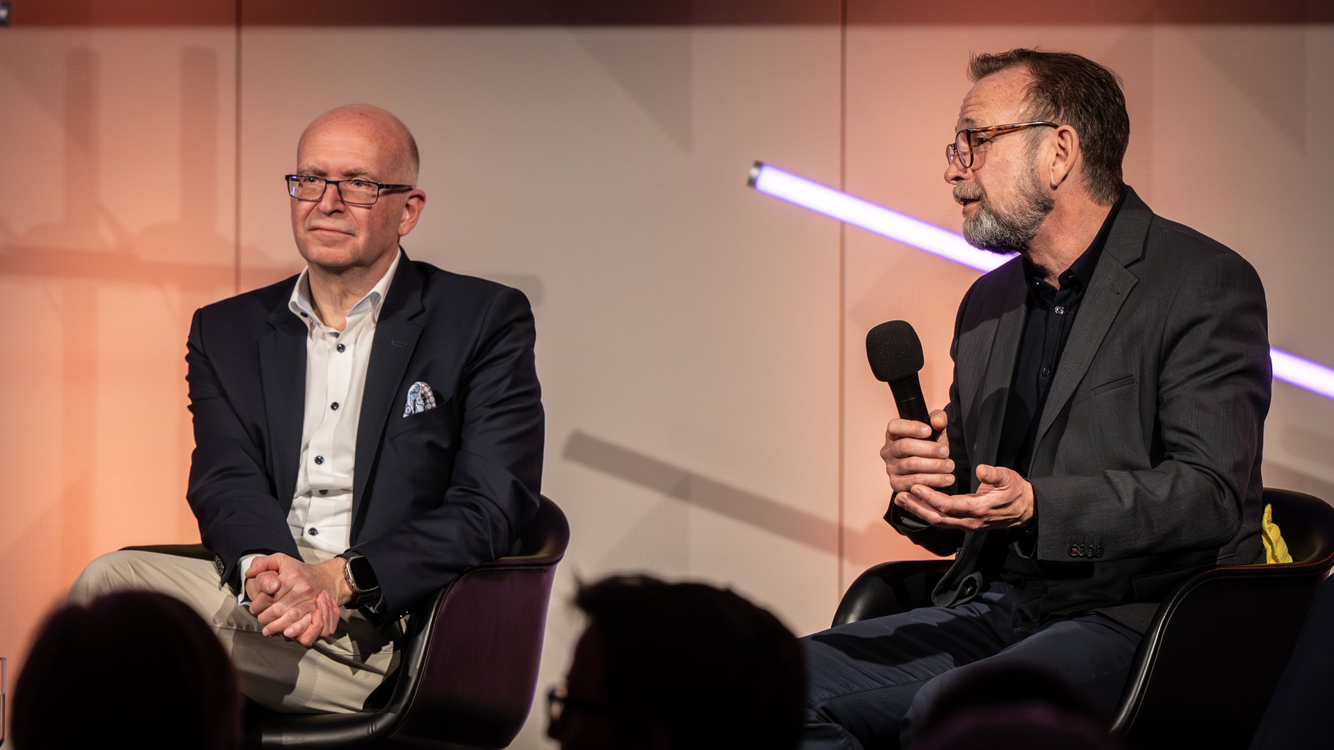 Dr. Martin Salomon sitzt neben Prof. Dr. Jürgen Janek und spricht in ein Mikrofon.