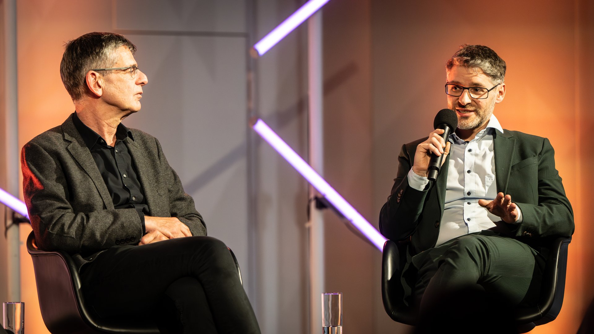 Gregor Dilger, Geschäftsführer Bundesverband Geothermie, sitzt neben Prof. Dr. Hartmut Zohm und spricht in ein Mikrofon.