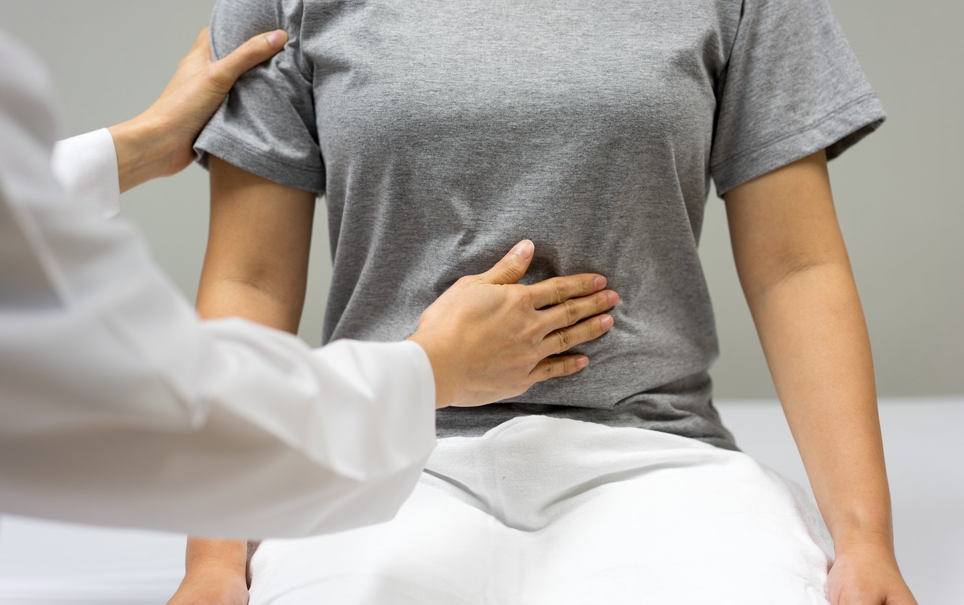 WJ26_Frauengesundheit_Untersuchung Eine Ärztin tastet eine Patientin in der Bauchgegend ab.