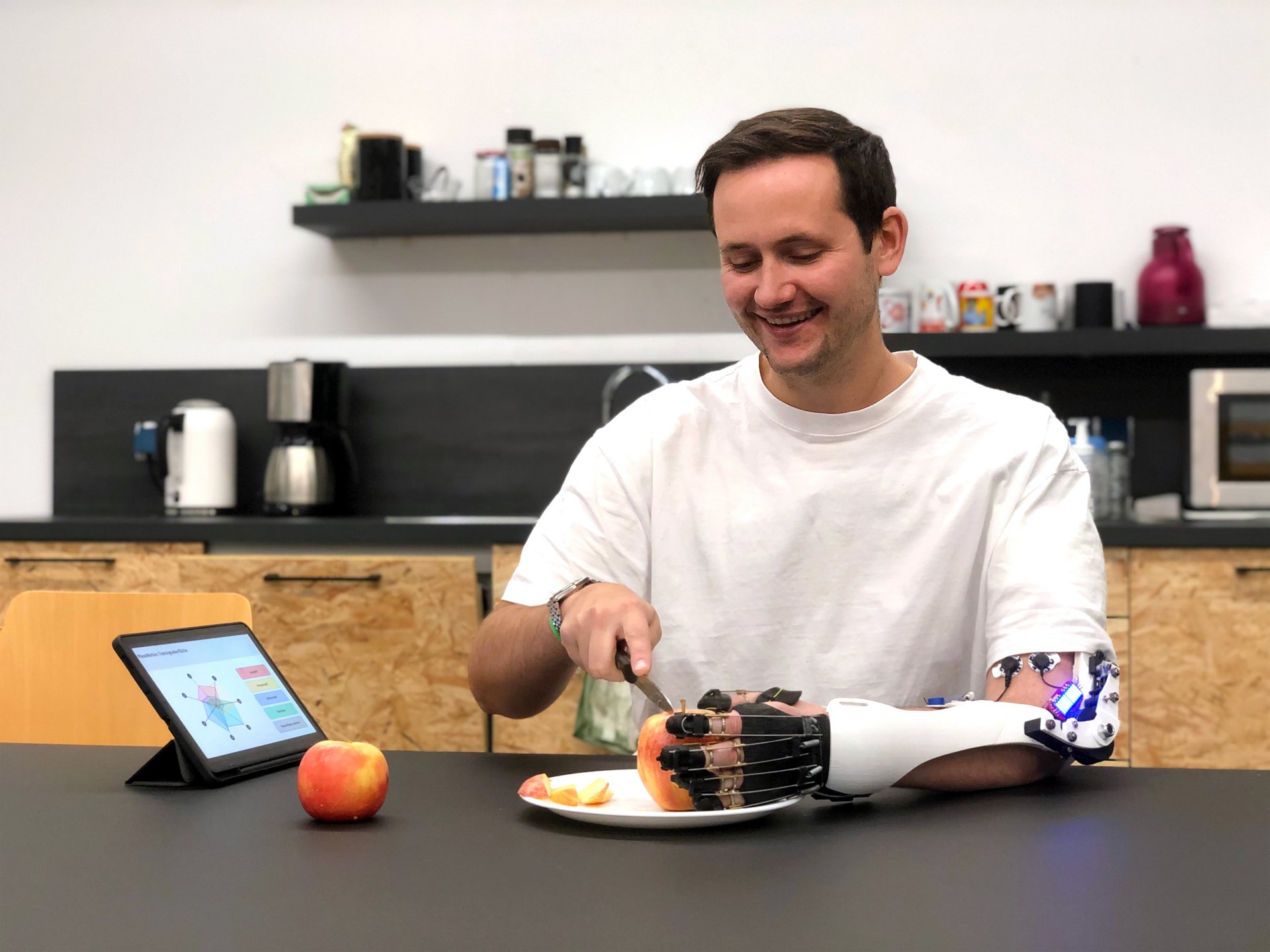 Eine Person mit gelähmtem Arm und einer interaktiven Armorthese.