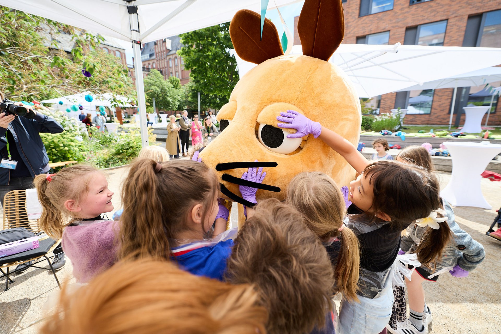 Acht Kinder streicheln die Maus als Walking Act.