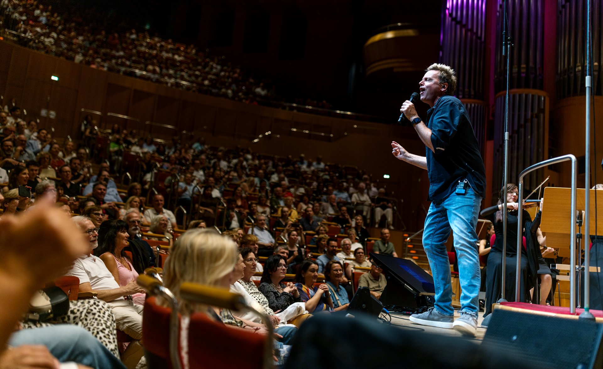 Mirko Bäumer von der Band Bläck Fööss auf der Bühne der Kölner Philharmonie, davor Publikum
