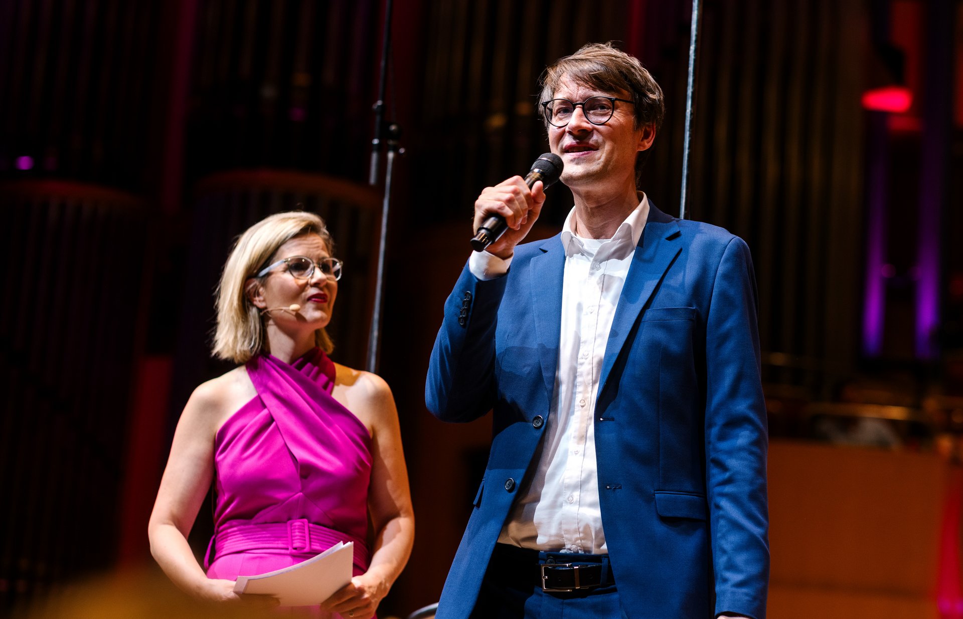 Moderatorin und Wissenschaftler auf der Bühne der Kölner Philharmonie beim Konzert von Noten und Neuronen