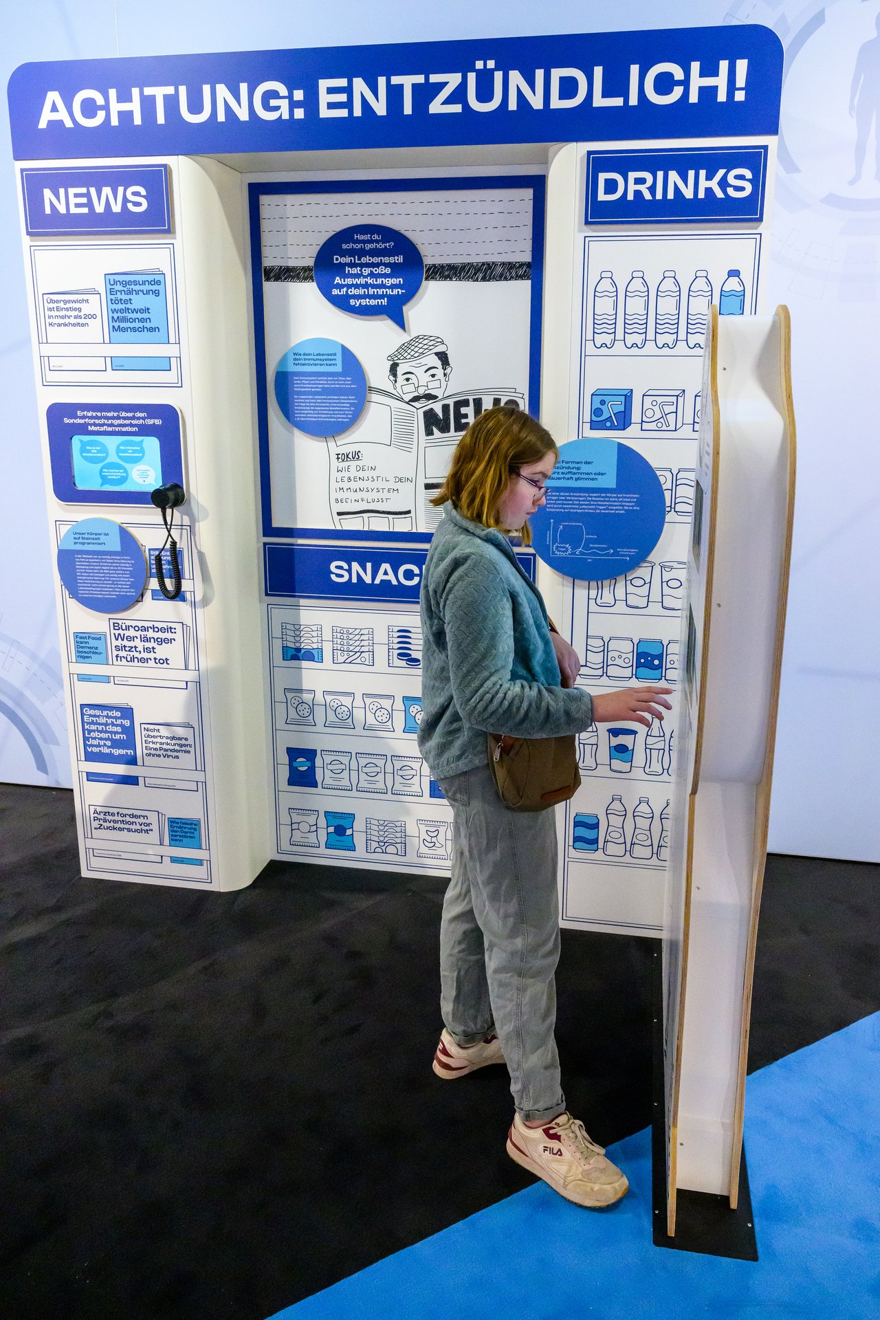 Exponat auf der MS Wissenschaft: Zeitungsstand mit Informationen zu Lebensstil und Gesundheit.