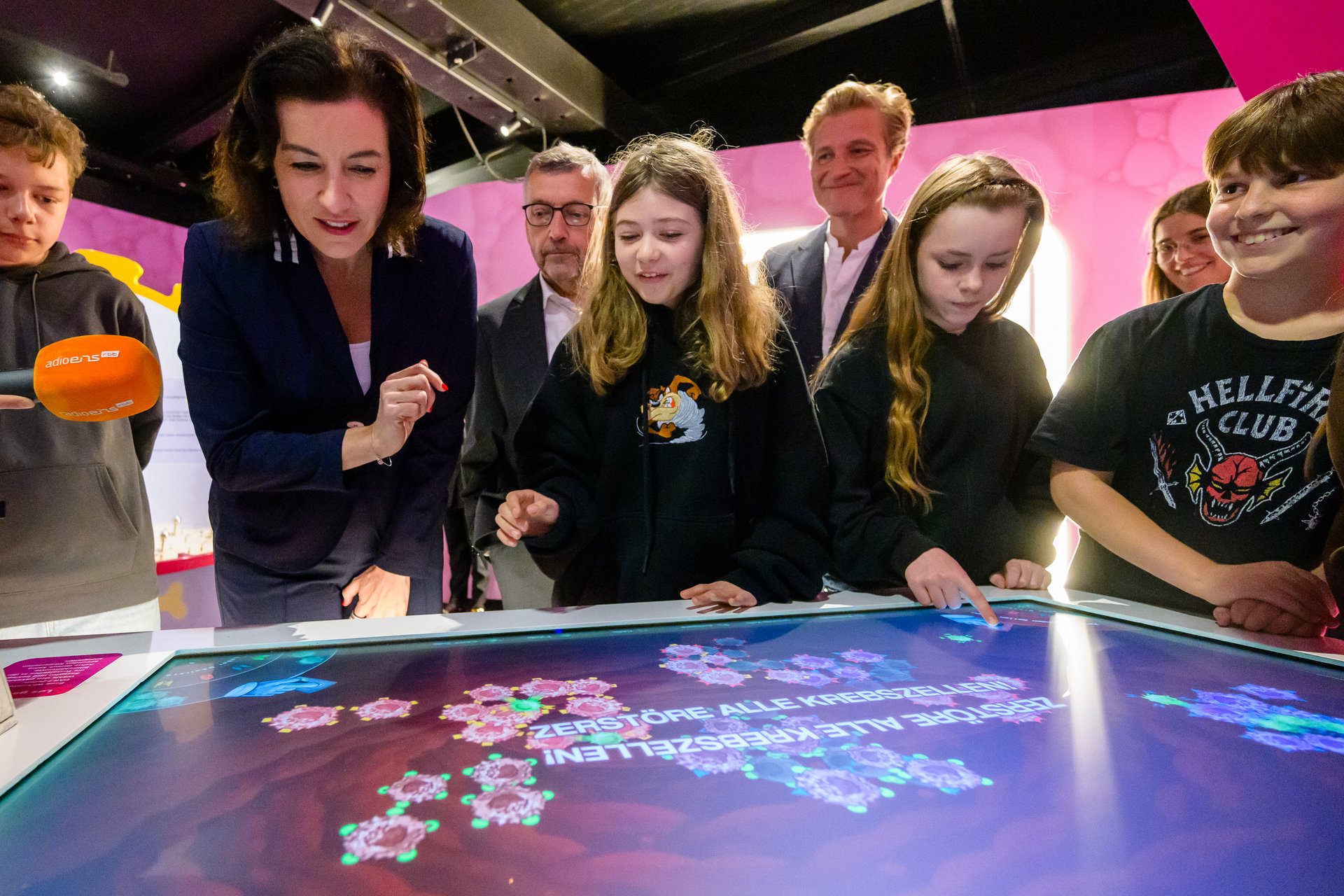 Bundesministerin für Forschung, Technologie und Raumfahrt Dorothee Bär spielt mit Kindern an einem großen Touchscreen.