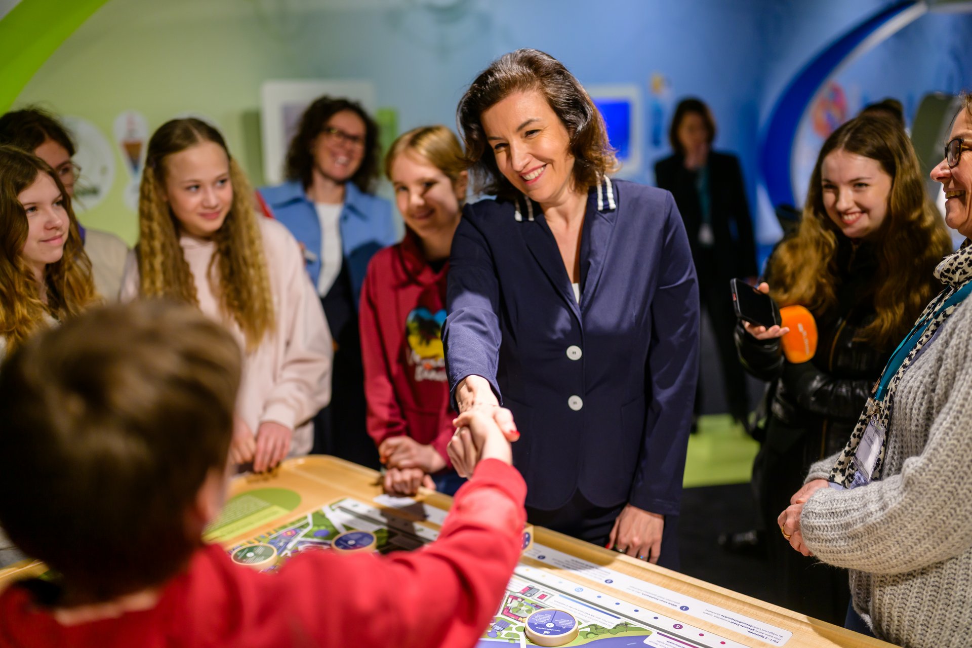 Bundesministerin für Forschung, Technologie und Raumfahrt Dorothee Bär gibt einem Jungen die Hand.