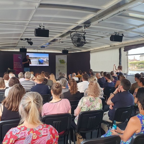 Ein Forscher stellt vor dem Publikum an Bord der MS Wissenschaft seine Forschungsergebnisse vor.