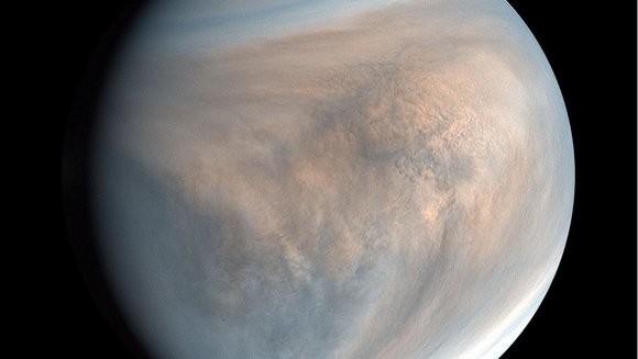 Der Planet Venus gehüllt in bläulich und orange erscheinende Wolken vor schwarzem Hintergrund. 