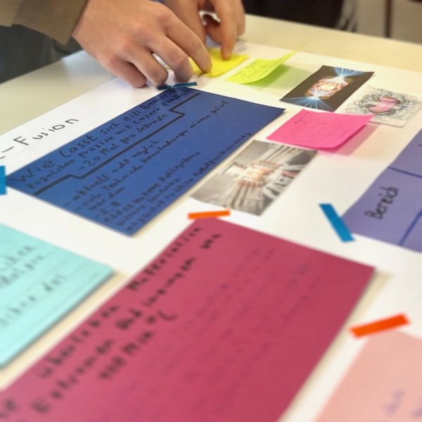Auf einem Tisch liegen verschiedenfarbige Karten mit Text. Der Text ist nicht lesbar.