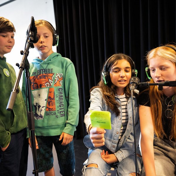 Schülerinnen und Schüler nehmen ein Hörspiel auf.