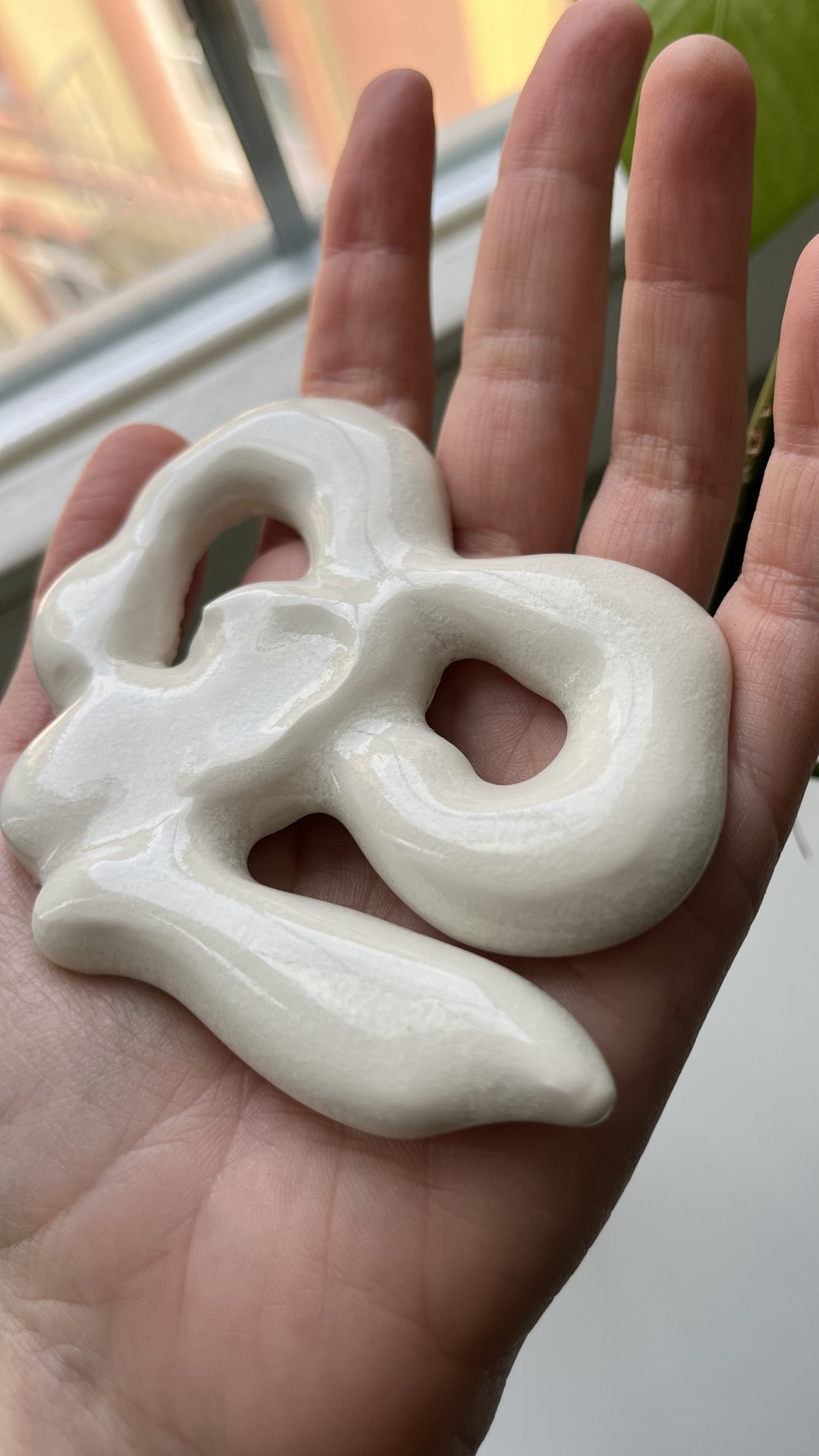 Hand hält eine Porzellanskulptur.