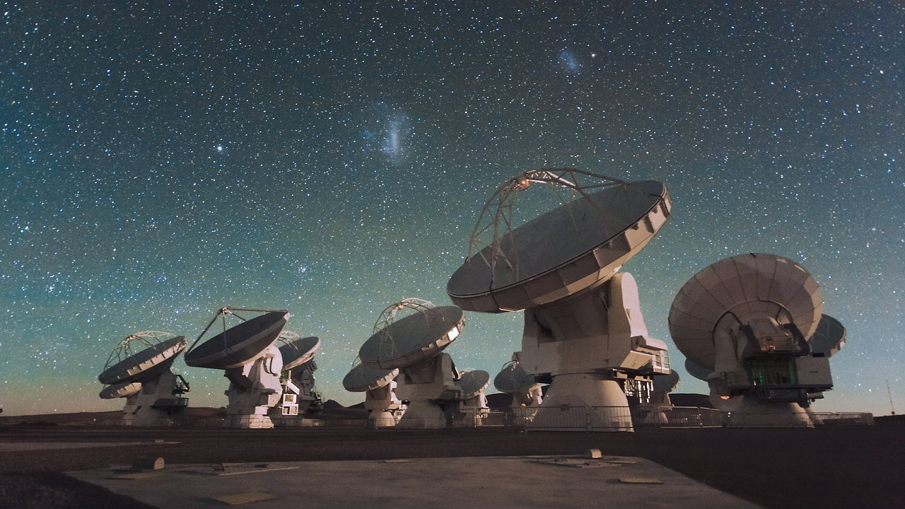 Das Atacama Large Millimeter/Submillimeter Array (ALMA) in Chile bei Nacht. Teile der Milchstraße sind am Himmel zu erkennen.
