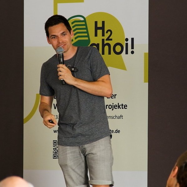 Philipp Weisenburger mit einem Mikrofon in der Hand.