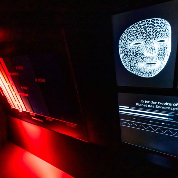 Ein Bildschirm zeigt ein Bild einer weißen Maske in einem dunklen Raum