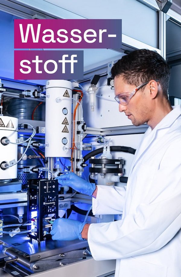 Wissenschaftler an einem AEM-Elektrolyse-Teststand, darüber der Text „Wasserstoff“.