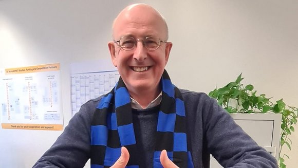Porträt Prof. Dr. med. Andreas Goette (Projektleiter FanBeats und Kardiologe), streckt beide Daumen nach oben und lächelt in die Kamera. Er trägt einen Schal des SC Paderborn 07. 
