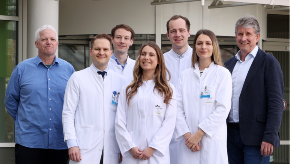 Gruppenbild der Projektverantwortlichen, die nebeneinander stehen und freundlich in die Kamera lächeln.