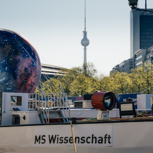Projektbild des Frachtschiffes der "MS Wissenschaft" mit einer große Attrappe des Mondes an Deck.