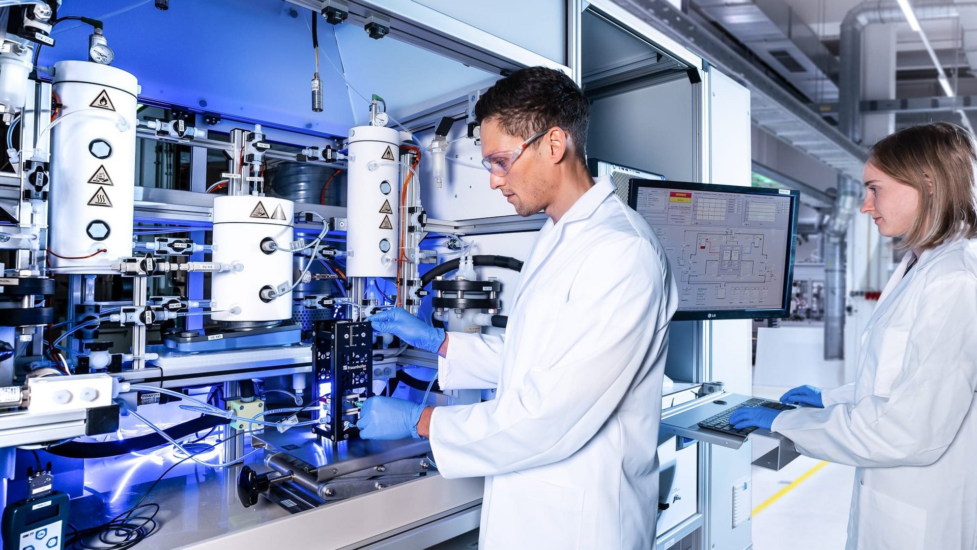 Wissenschaftler und Wissenschaftlerin an einem AEM-Elektrolyse-Teststand.