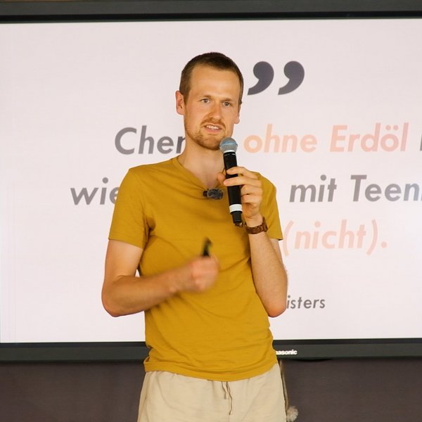 Arne Nisters vor einer Leinwand an Bord der MS Wissenschaft.