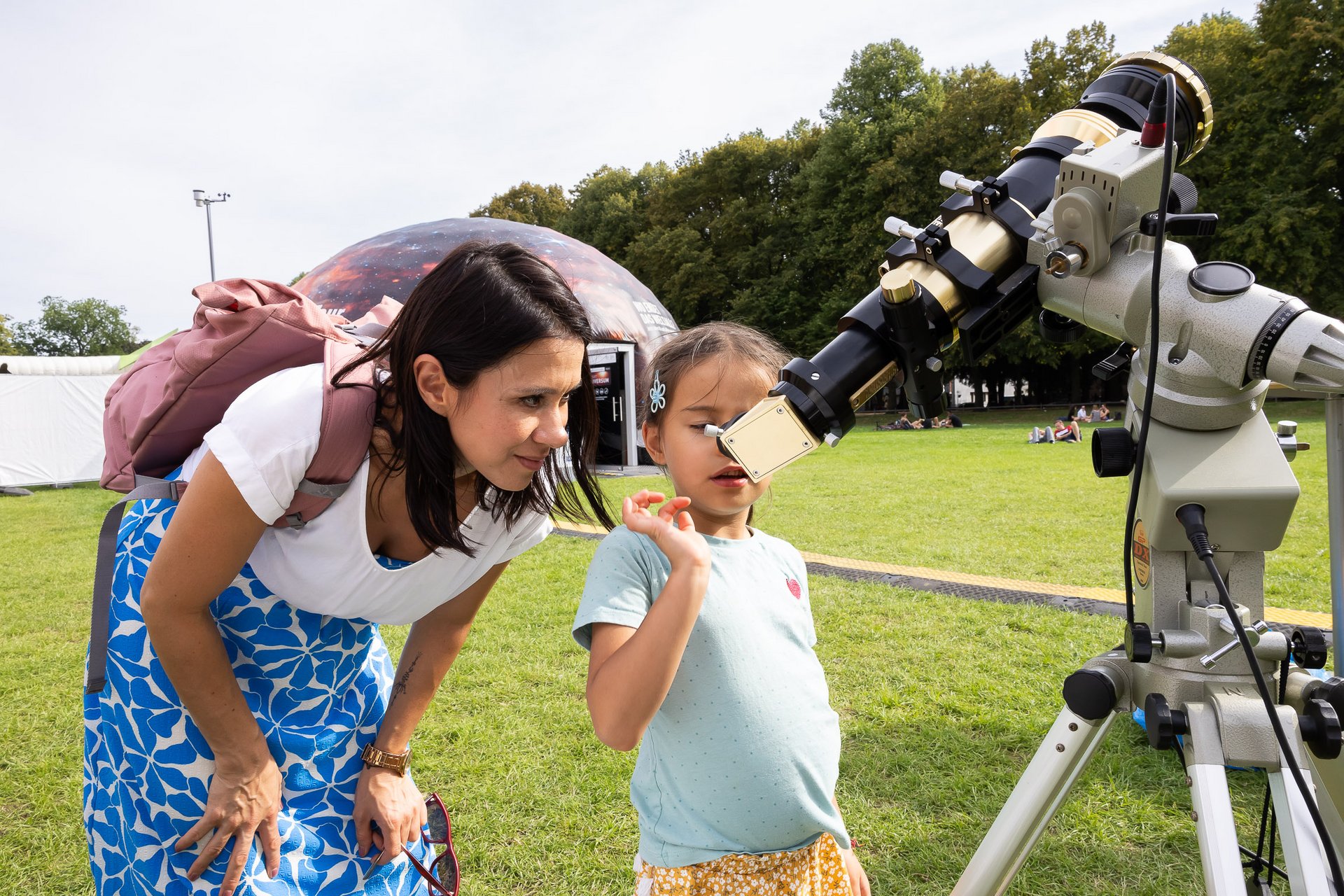 Eine Frau und ein Kind schauen durch ein Teleskop 