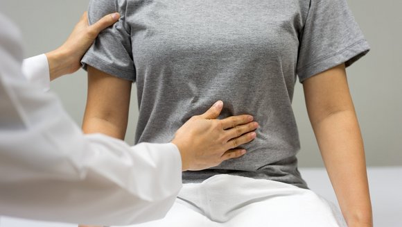 Eine Ärztin tastet eine Patientin in der Bauchgegend ab.