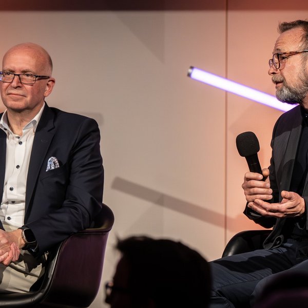 Dr. Martin Salomon sitzt neben Prof. Dr. Jürgen Janek und spricht in ein Mikrofon.