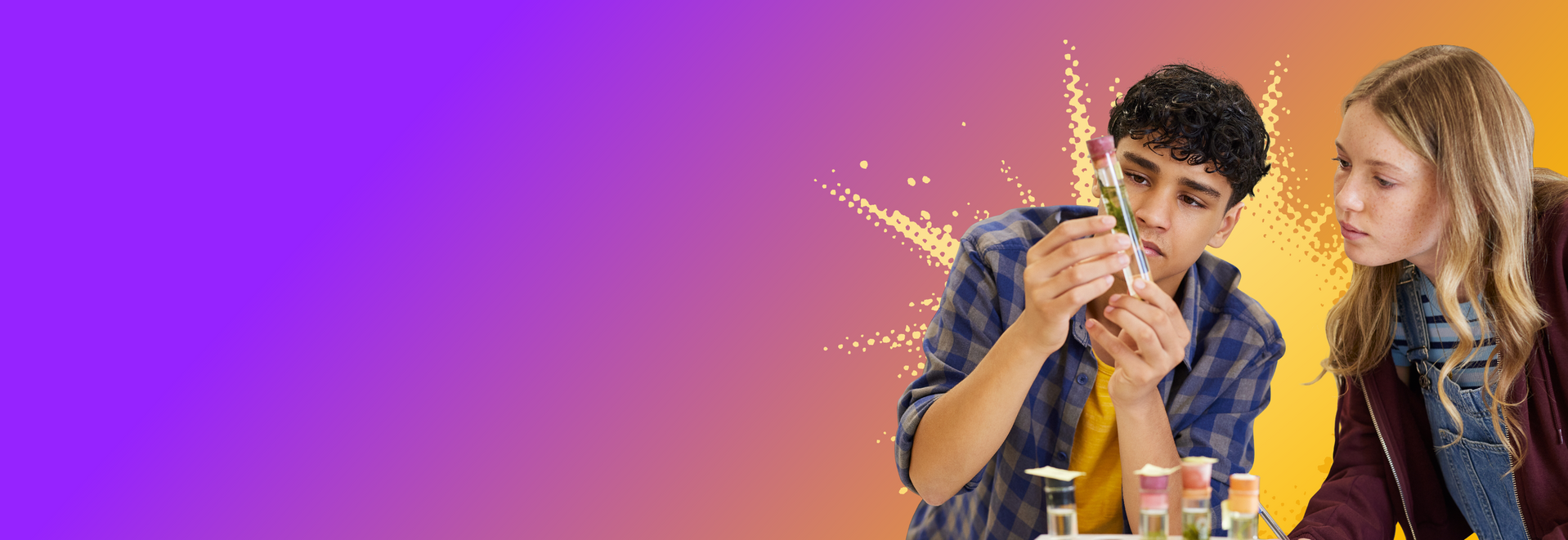 Zwei junge Personen schauen sich Reagenzgläser mit Flüssigkeiten an