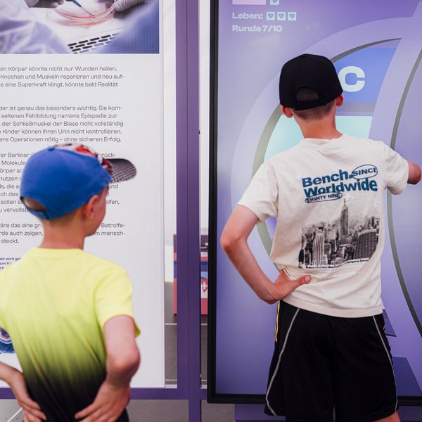 Zwei Kinder schauen sich einen Bildschirm auf der Health XP an.