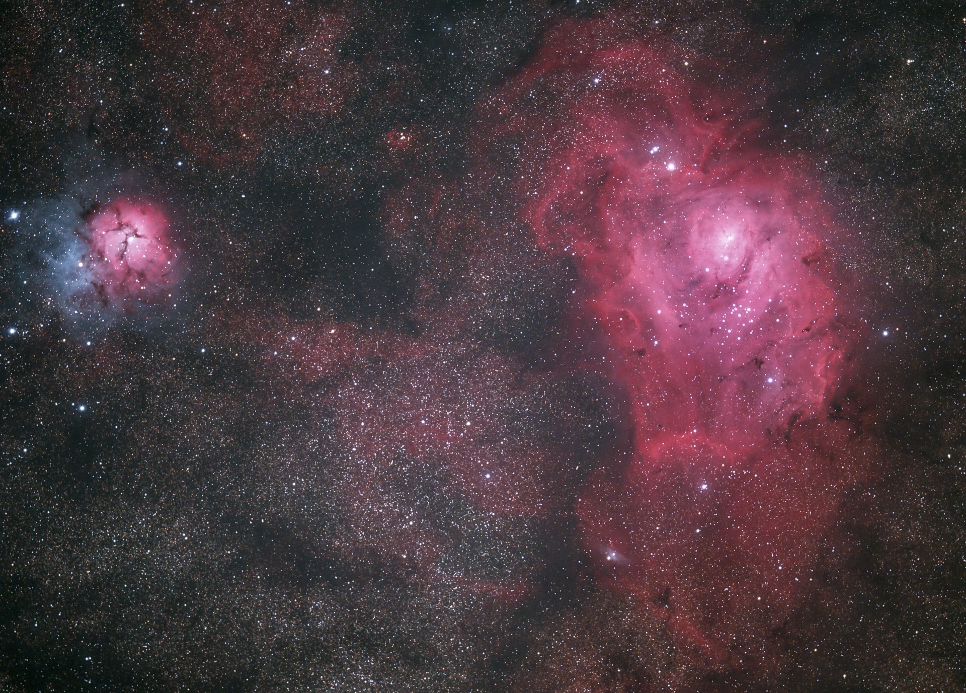 Viele Sterne und Sternnebel, rechts ist eine große rosa Galaxie zu erkennen