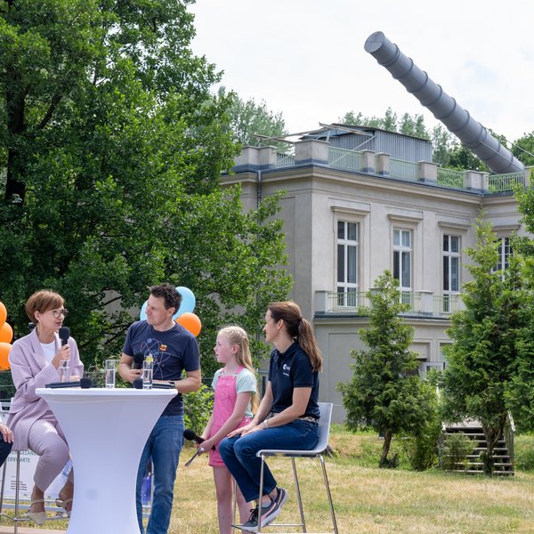 Mehrere Personen an einem Tisch in einem Garten