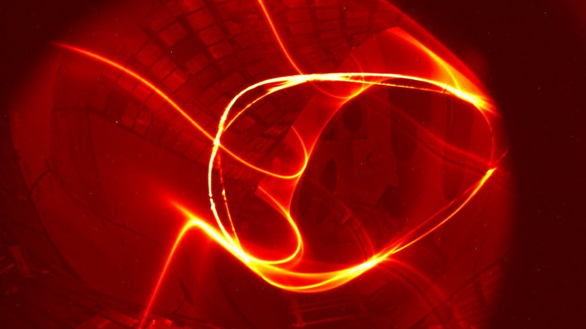 Leuchtendes Plasma: Rot-orangenes Plasma in ringförmiger Bewegung innerhalb einer Fusionsanlage.