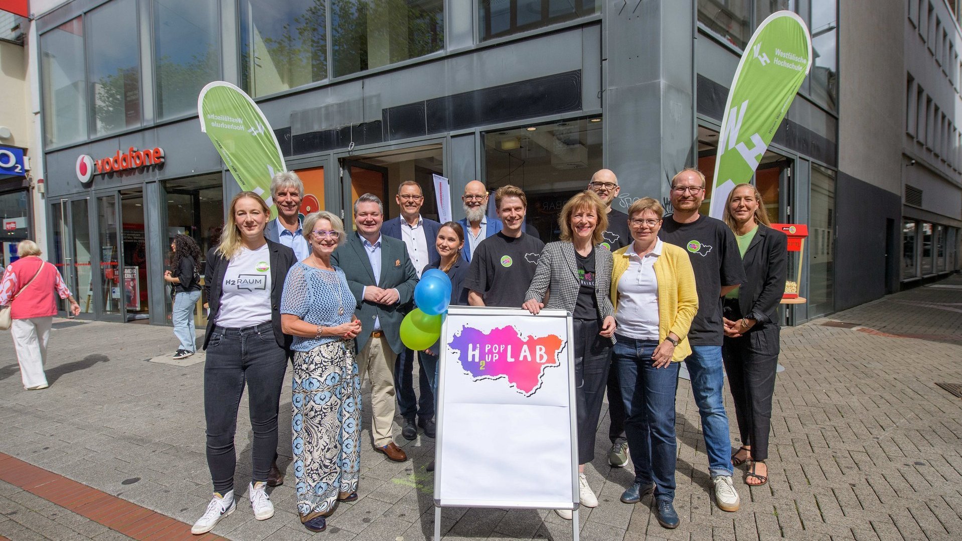 Das Projektteam vom H2PopUpLab und Gäste stehen vor dem Labor in der Gelsenkirchener Innenstadt.