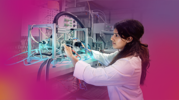 Frau im weißen Kittel arbeitet an einer technischen Apparatur, aus der Schläuche herausragen