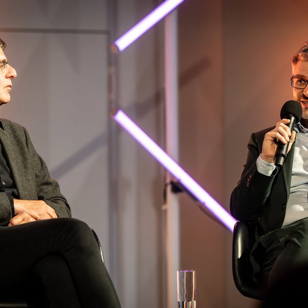 Gregor Dilger, Geschäftsführer Bundesverband Geothermie, sitzt neben Prof. Dr. Hartmut Zohm und spricht in ein Mikrofon.