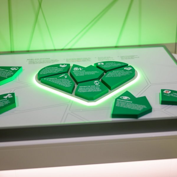 Eine grüne Herz-Skulptur mit Informationen zu Herzgesundheit.