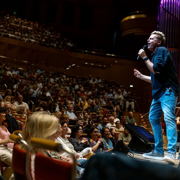 Mirko Bäumer von der Band Bläck Fööss auf der Bühne der Kölner Philharmonie, davor Publikum