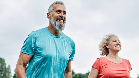 Ein Mann und eine Frau mittleren Alters joggen im Freien.