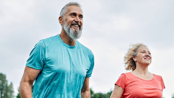 Ein Mann und eine Frau mittleren Alters joggen im Freien.