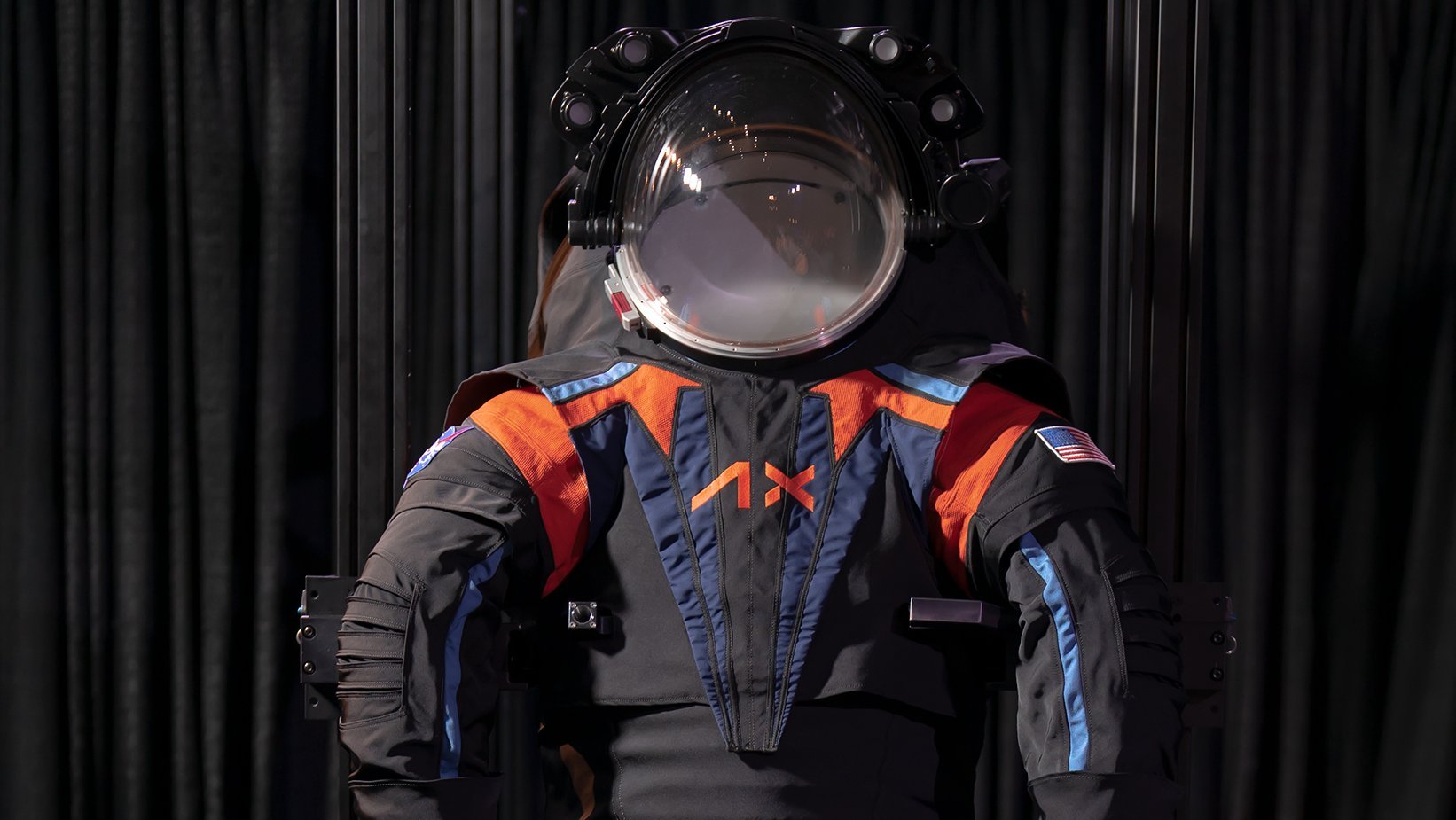 Ein schwarzer Raumanzug mit orangen und blauen Details einschließlich Helm