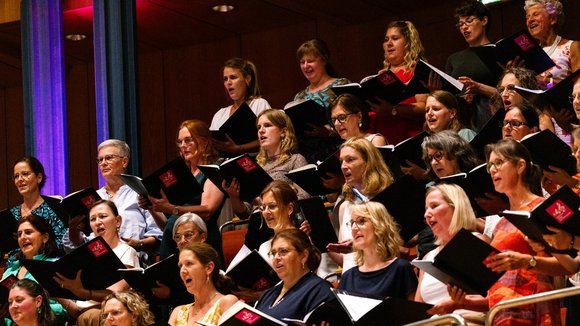 Chor mit Notenheften auf den Sitzrängen der Kölner Philharmonie