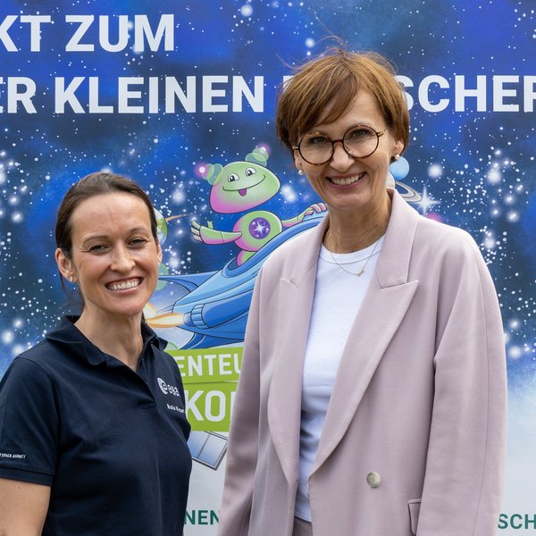 Bundesministerin Stark-Watzinger und eine Frau vor Plakat