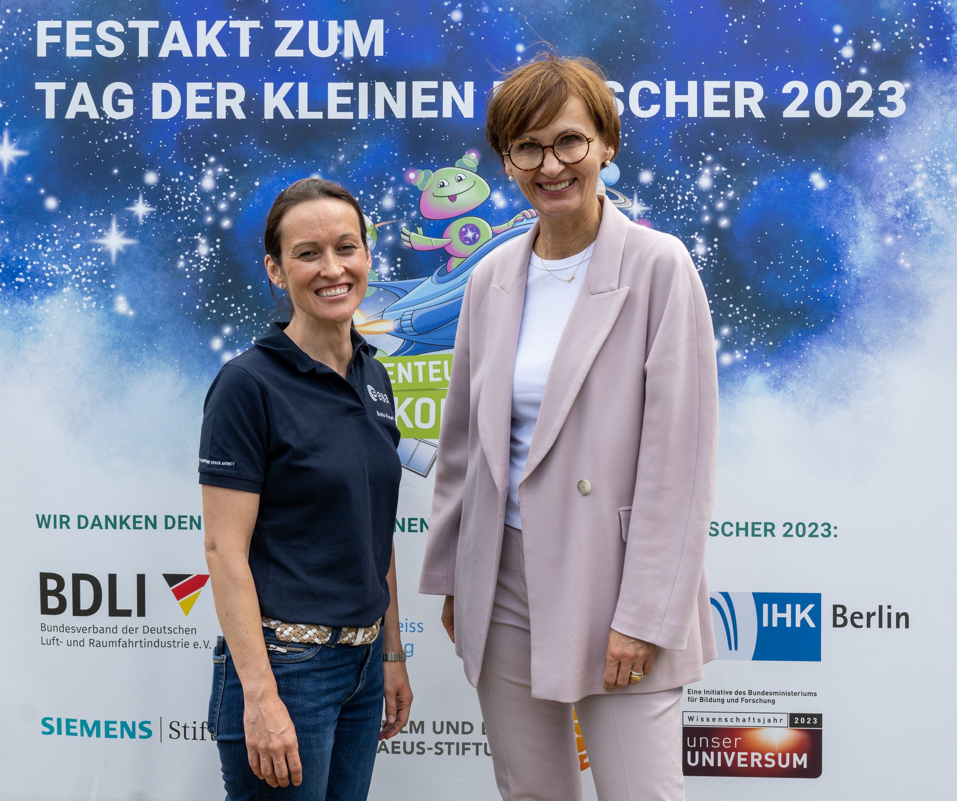 Bundesministerin Stark-Watzinger und eine Frau vor Plakat