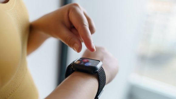 Eine Frau tippt auf ihrer Smartwatch.