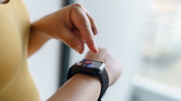 Eine Frau tippt auf ihrer Smartwatch.