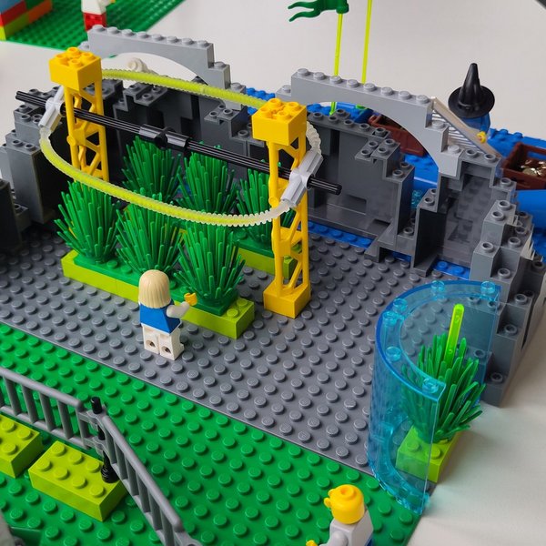 Modell aus Klemmbausteinen mit Wänden, Pflanzen, Schläuchen und Figuren auf einem Tisch