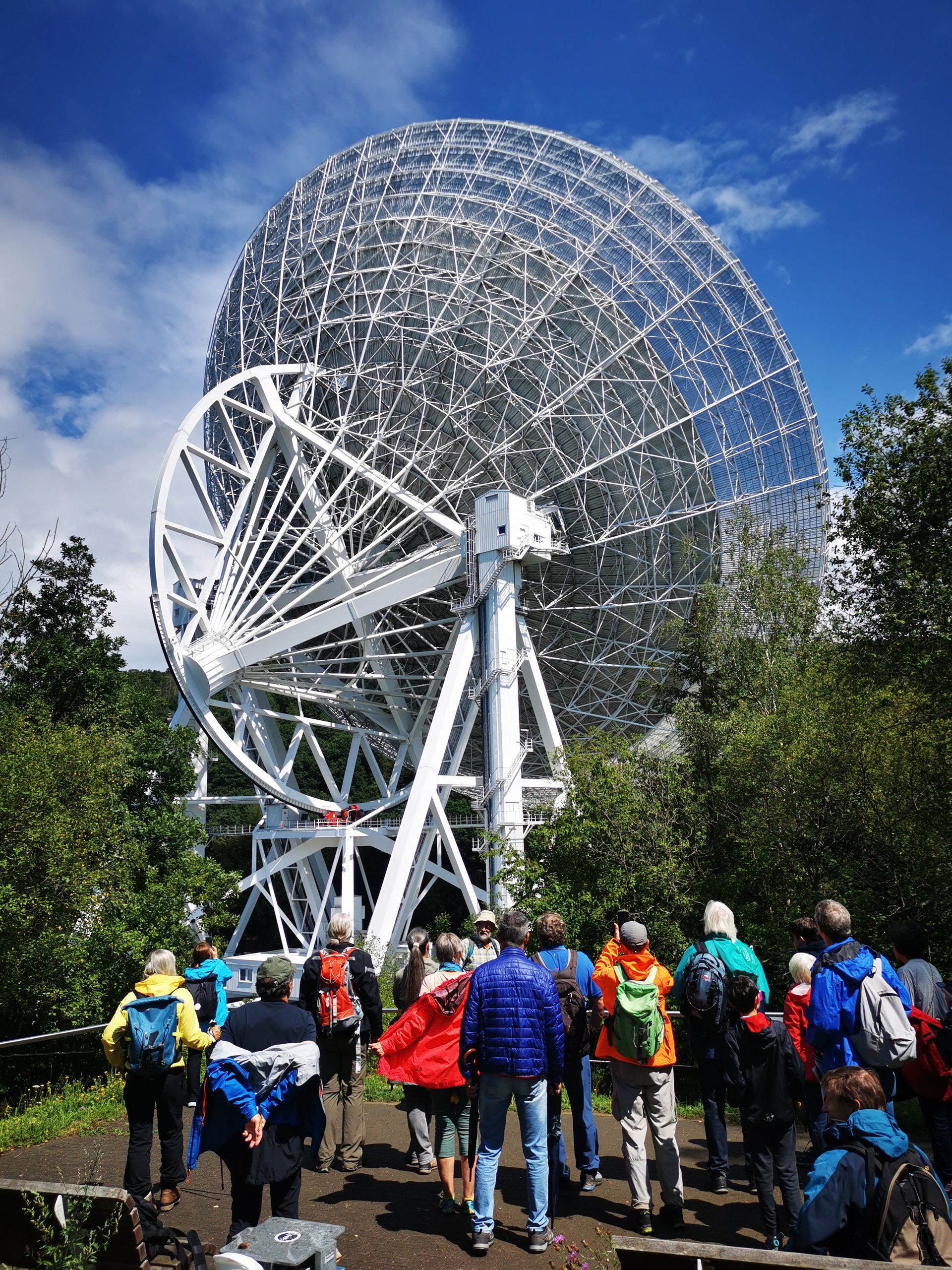 Eine Gruppe Menschen vor dem Radioteleskop Effelsberg