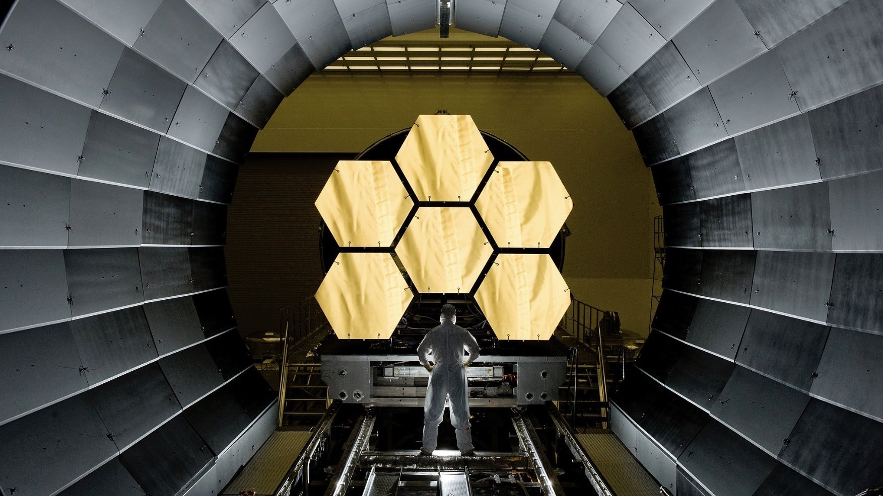 Ein NASA-Ingenieur steht vor großen Spiegelelementen des James-Webb-Teleskopes.